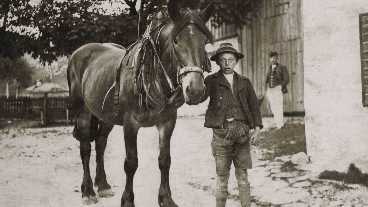 „Rußbach Hias“ vor dem Wagnerwirtsstall; ca. 1915 (Kommentar Gimpl Georg: Rußbach Hias - dahinter Bscheer - vor dem Wagnerwirtsstall - möglicherweise ist dieser sogar zum Saal dann umgebaut worden. Davor ist jedenfalls schon der Kastanienbaum. Das Haus dahinter könnte das Unterschmied sein und das Steinböckhäusl womöglich noch gar nicht stehen. Beachte vorne das Pflaster, das ist auch auf einem Foto mit den Musikern drauf.)  