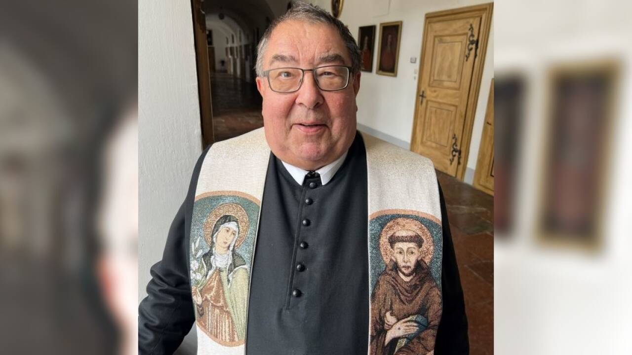 Pater Franz mit der Stola aus Rom. Sie zeigt den Heiligen Franziskus und die Heilige Clara.  