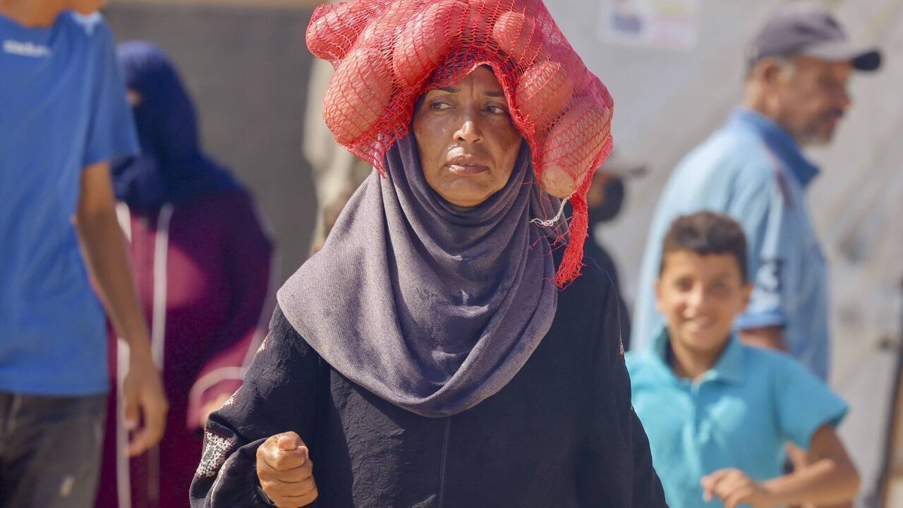 Eine Palästinenserin trägt in Rafah eine Lebensmittelration. Eine Palästinenserin trägt in Rafah eine Lebensmittelration.