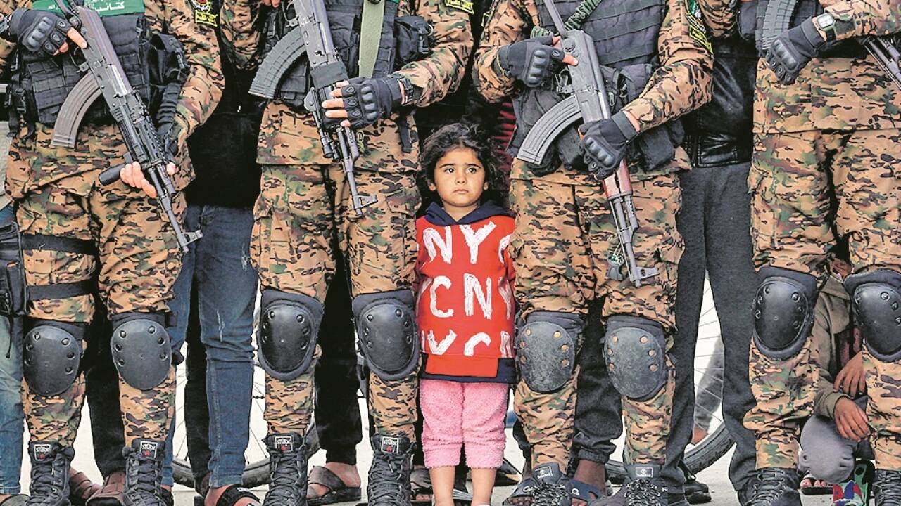 Palästinensisches Kind zwischen Hamas-Soldaten bei einer Geiselübergabe. 