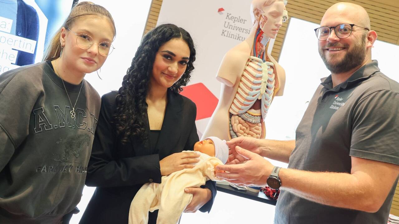 Riana und Amrit mit Stefan Kaltenhuber und einer Puppe des Kepler-Klinikums. 