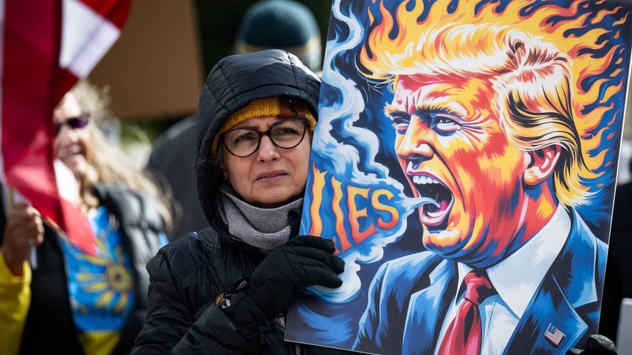 Eine Frau protestiert in Wyoming und bezichtigt Trump der Lüge.  