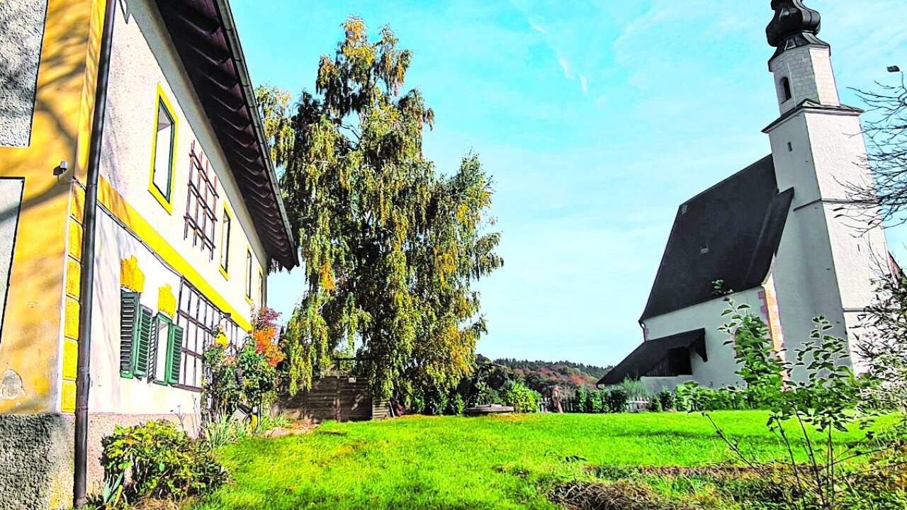 Der Garten hinter dem Pfarrhof. Auf dem Gelände steht auch eine Kirche.  