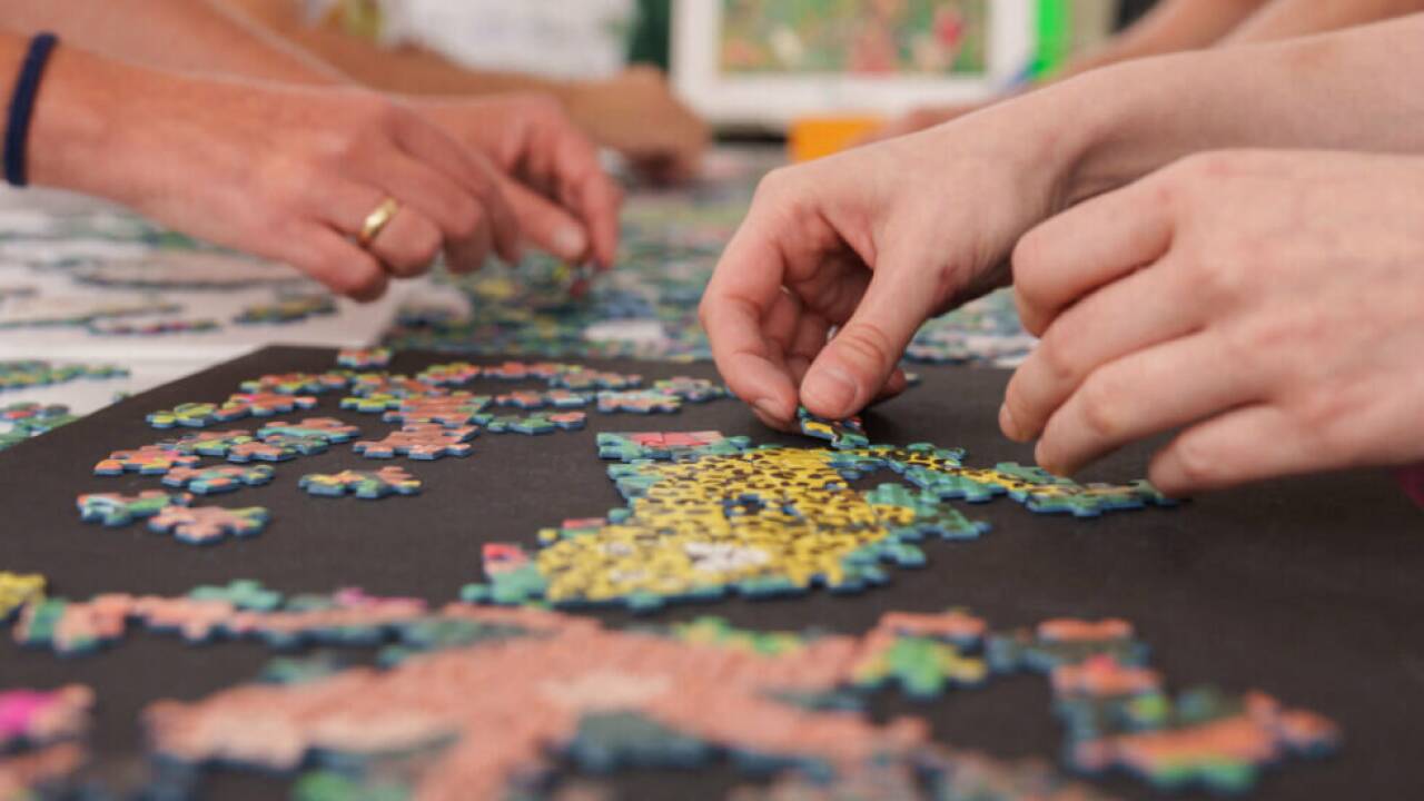 Nach dem gemeinsamen Puzzeln bewegen sich zwei Personen synchron Nach dem gemeinsamen Puzzeln bewegen sich zwei Personen synchron