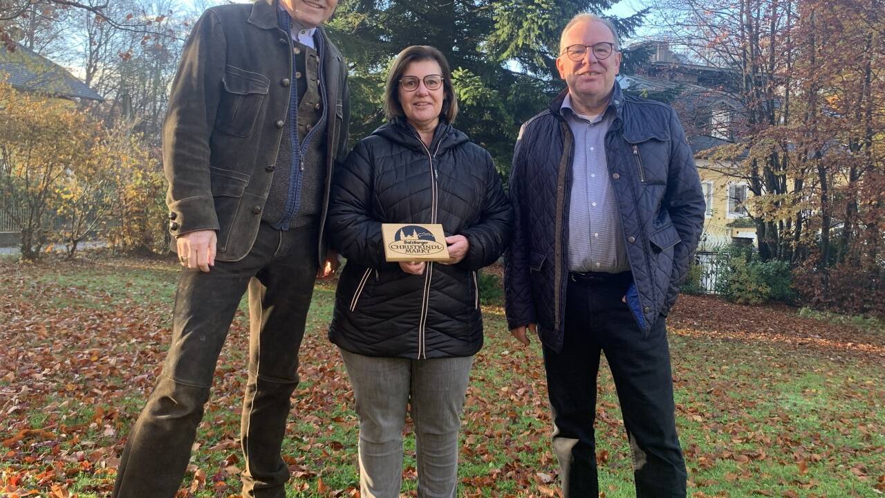 Wolfgang Haider, Obmann des Vereins Salzburger Christkindlmarkt (links), dankt Evelyne und Manfred Bauer für die Baumspende. 