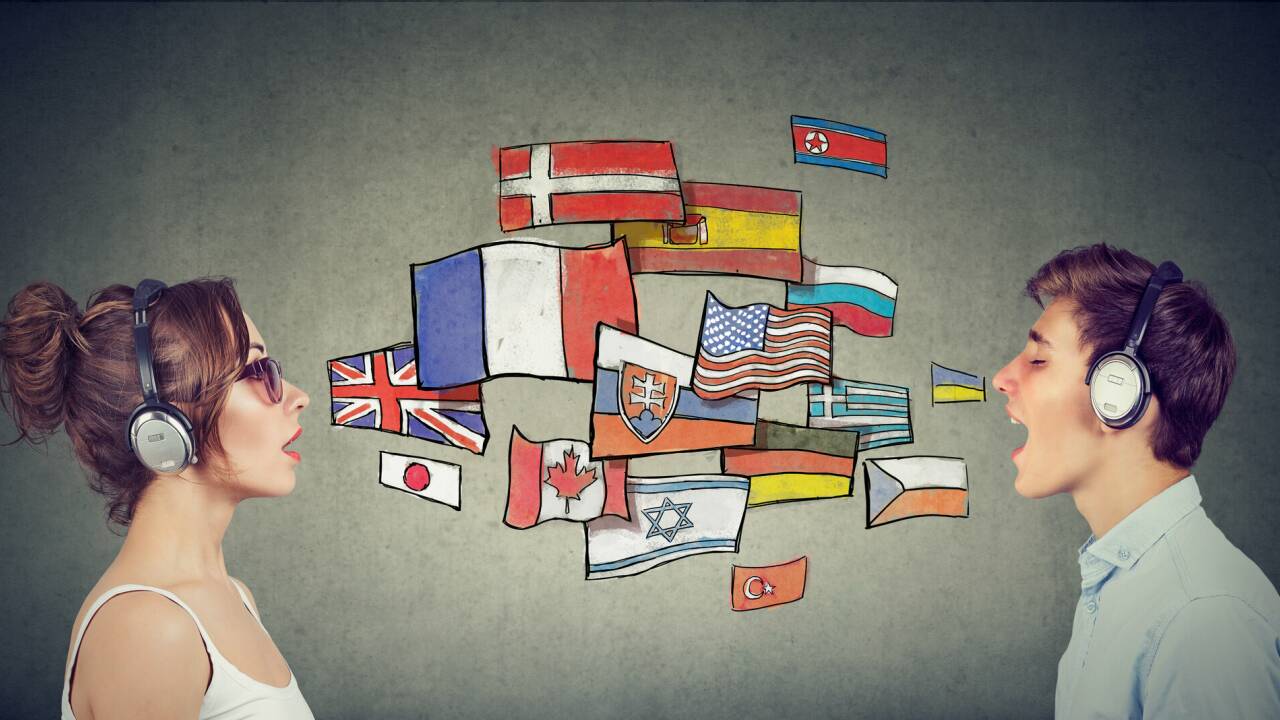 Eine junge Frau und ein junger Mann mit Kopfhörern lernen unterschiedliche Sprachen. 