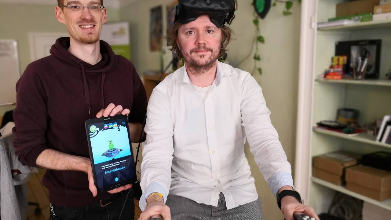 Thomas Layer-Wagner und Robert Praxmarer zeigen ihr Projekt für den Radfrühling. Praxmarer hat eine Virtual-Reality-Brille am Kopf.  