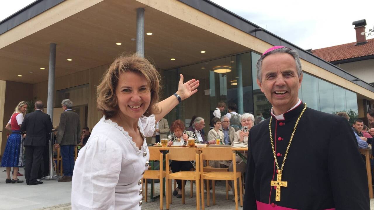 Maria Schwarzmann, Pfarrgemeinderatsobfrau der Pfarre St. Josef in Hallein-Neualm, und Weihbischof Hansjörg Hofer vor dem neuen Pfarrzentrum.  