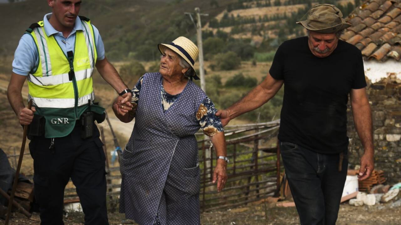 Ein Polizist bringt Bewohner von Monchique (Algarve/Portugal) in Sicherheit. 