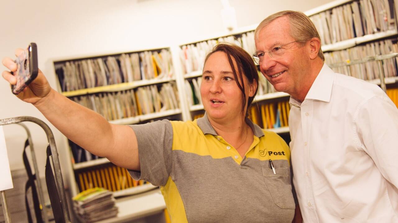 ... für ein Selfie posierend mit einer Postmitarbeiterin in Puch, ... 
