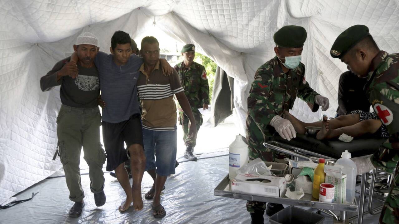 Helfer bringen einen Verletzten in ein Lazarett. 