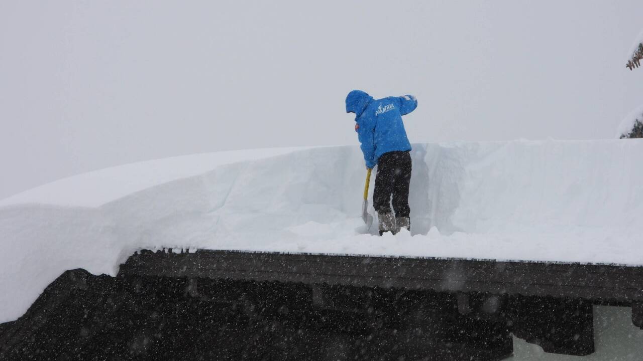 Ebenfalls in Hochfilzen schaufelt diese Person Schneemassen vom Hausdach. 