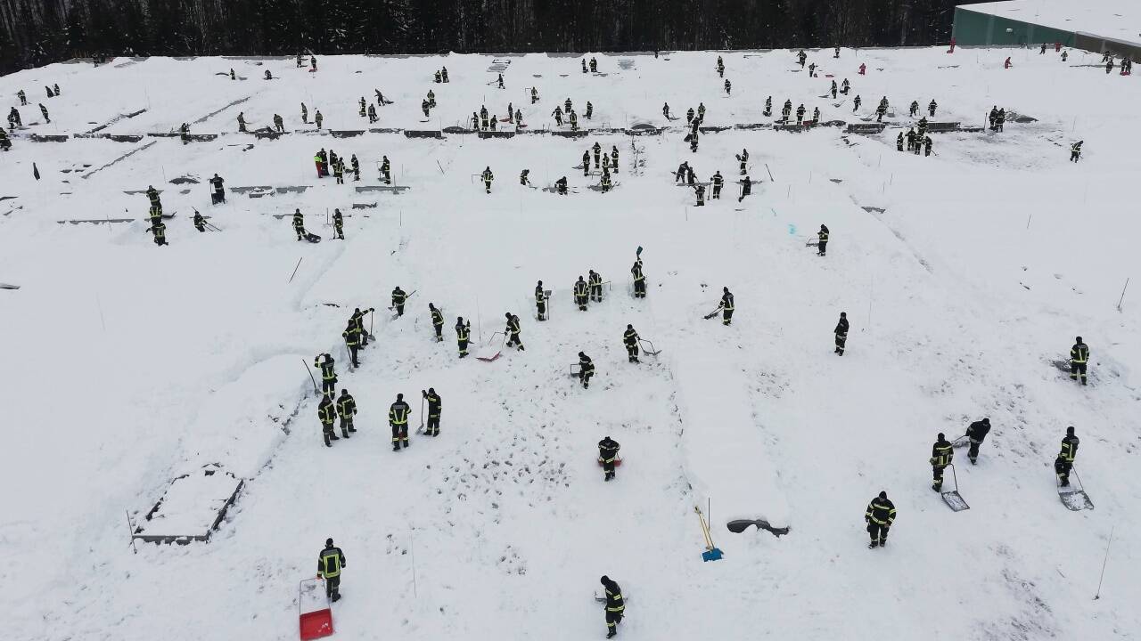 Feuerwehrleute und Bundesheersoldaten beim freischaufeln eines Daches einer Halle in Ebensee.  