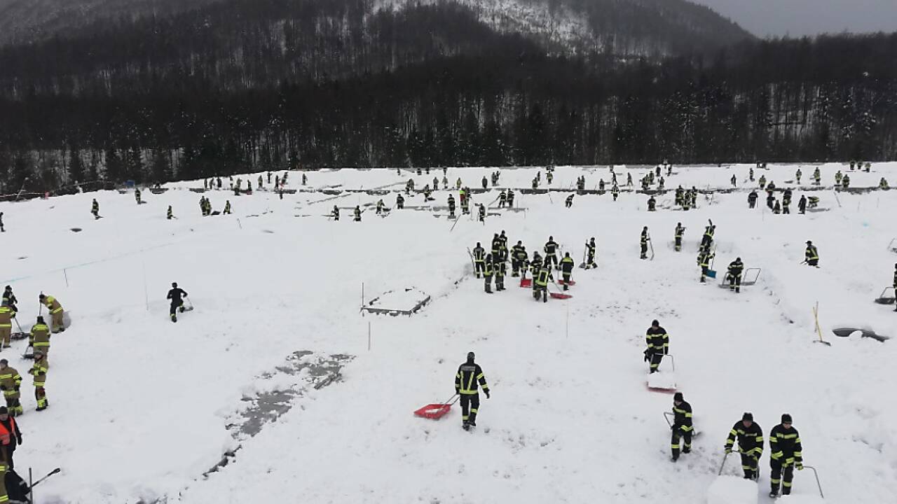 Freiwillige schaufeln Dach einer Halle in Ebensee frei 