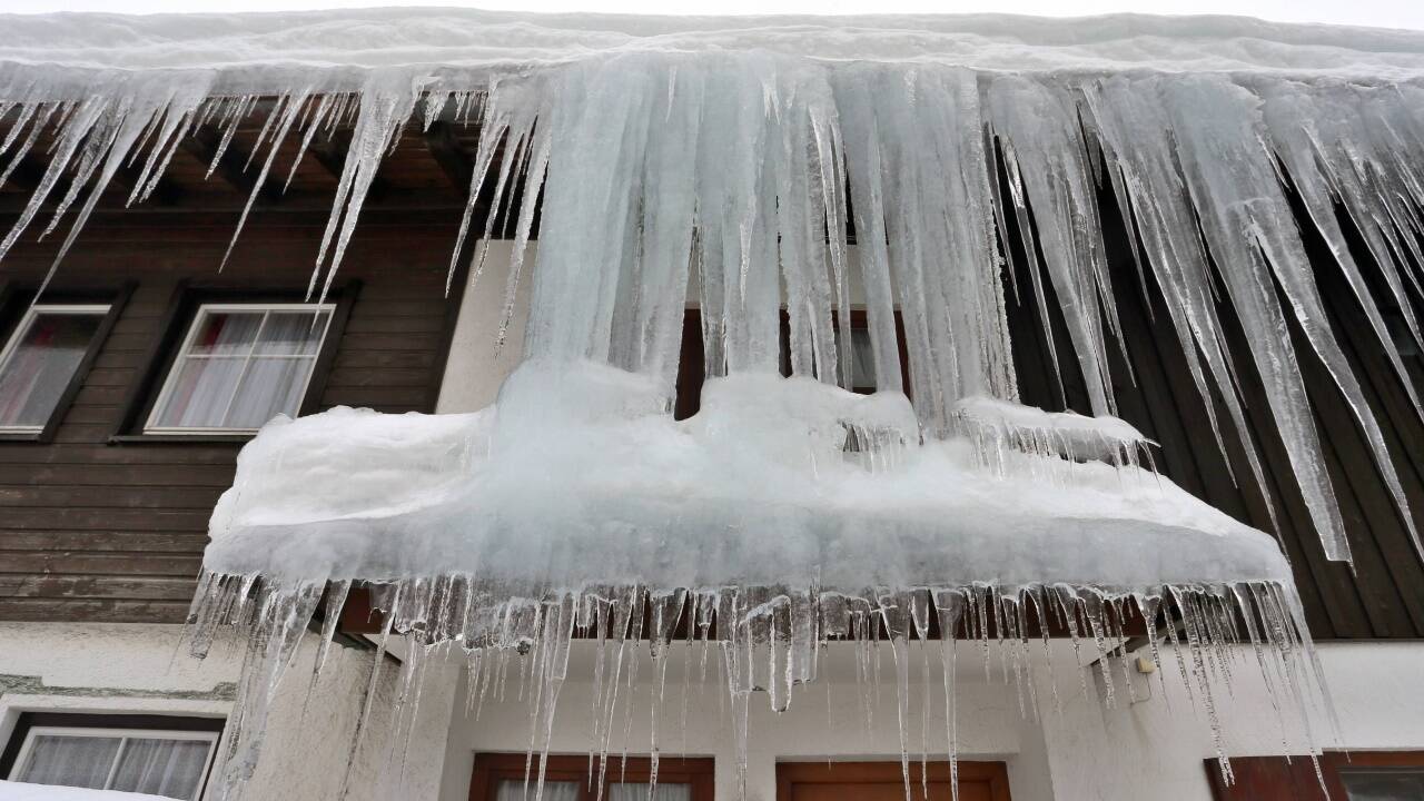 Bayern, Oberjoch: Ein Vorhang aus Eiszapfen hängt vor dem Fenster eines Wohnhauses.  