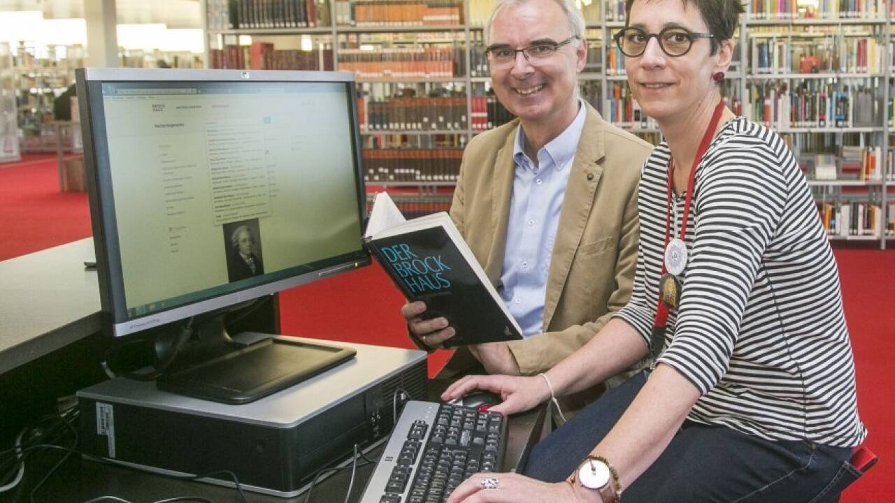 Zwei Versionen der Brockhaus-Enzyklopädie: Bibliotheksleiter Helmut Windinger mit der gedruckten Version, Bibliothekarin Alexandra Zima vor der Online-Version des Brockhaus. 