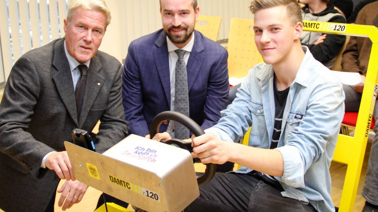 Erich Lobensommer (ÖAMTC Salzburg), Landesrat Stefan Schnöll und Schüler Andreas Leikermoser (17) von der Berufsschule in Wals am Fahrsimulator. 