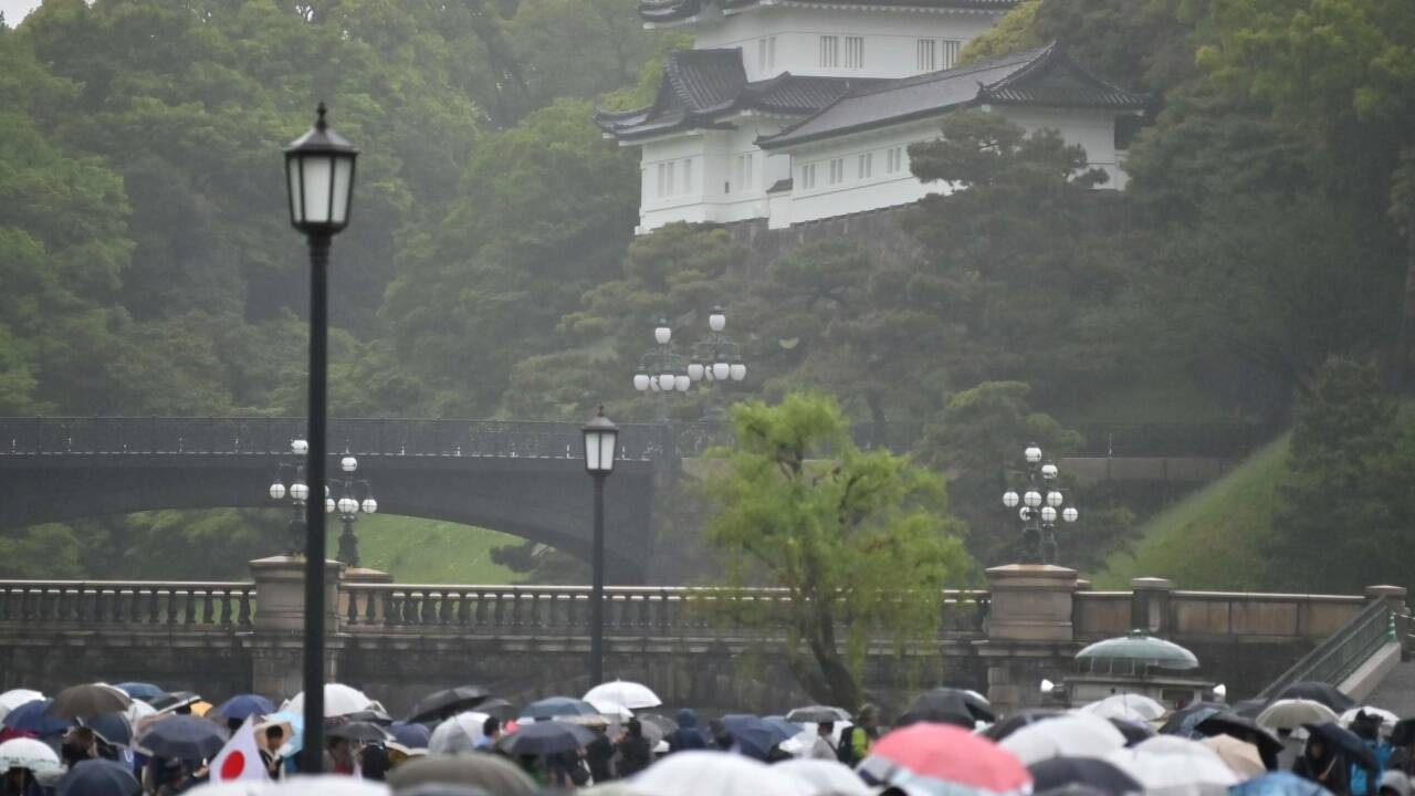 Die Öffentlichkeit war von der Zeremonie zwar ausgeschlossen, viele Japaner kamen aber dennoch in der Nähe des Kaiserpalasts zusammen. Das Wetter präsentierte sich allerdings wie hierzulande von seiner nassen Seite. 