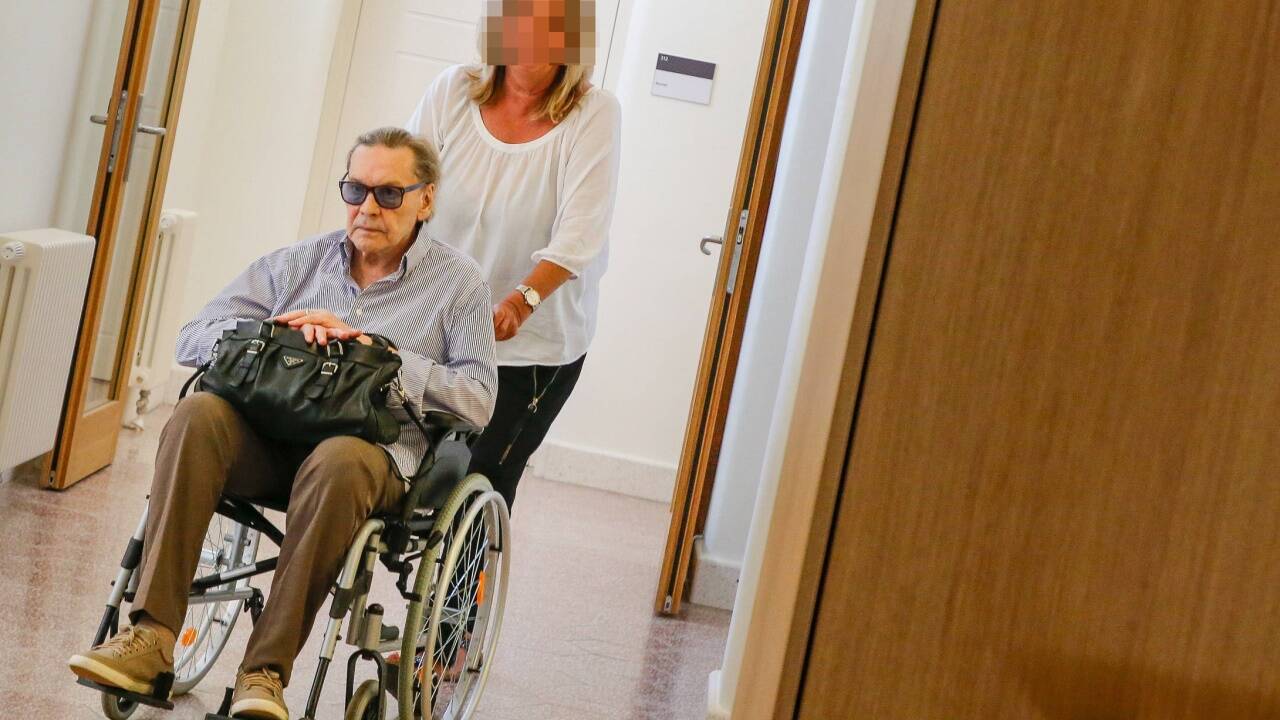 Schauspieler Helmut Berger wird von seiner Vertrauensperson in den Gerichtssaal gebracht.  