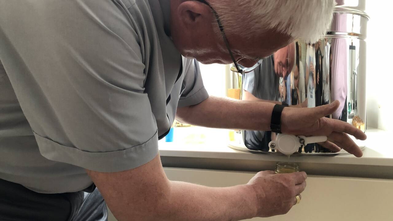 Der Erzbischof beim Abfüllen des Honigs.  