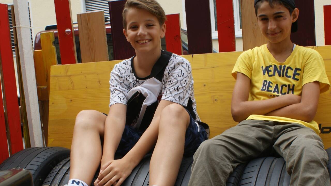Die beiden 13-jährigen Schüler Rijad und Arshavin (v.l.) entspannen gerne im Sitzbereich vor ihrem Jugendzentrum. 