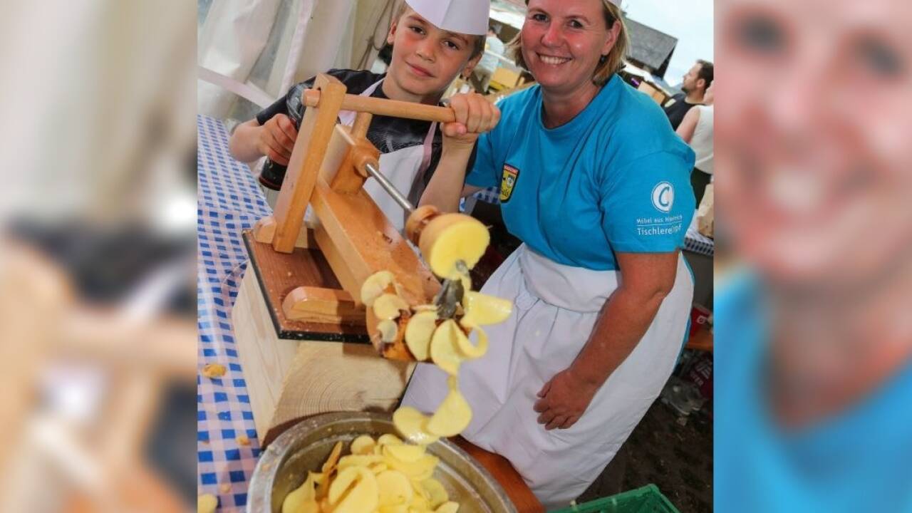 Raphael half Anni Czipf an der Bohrmaschine beim Drehen von Kartoffelchips. 