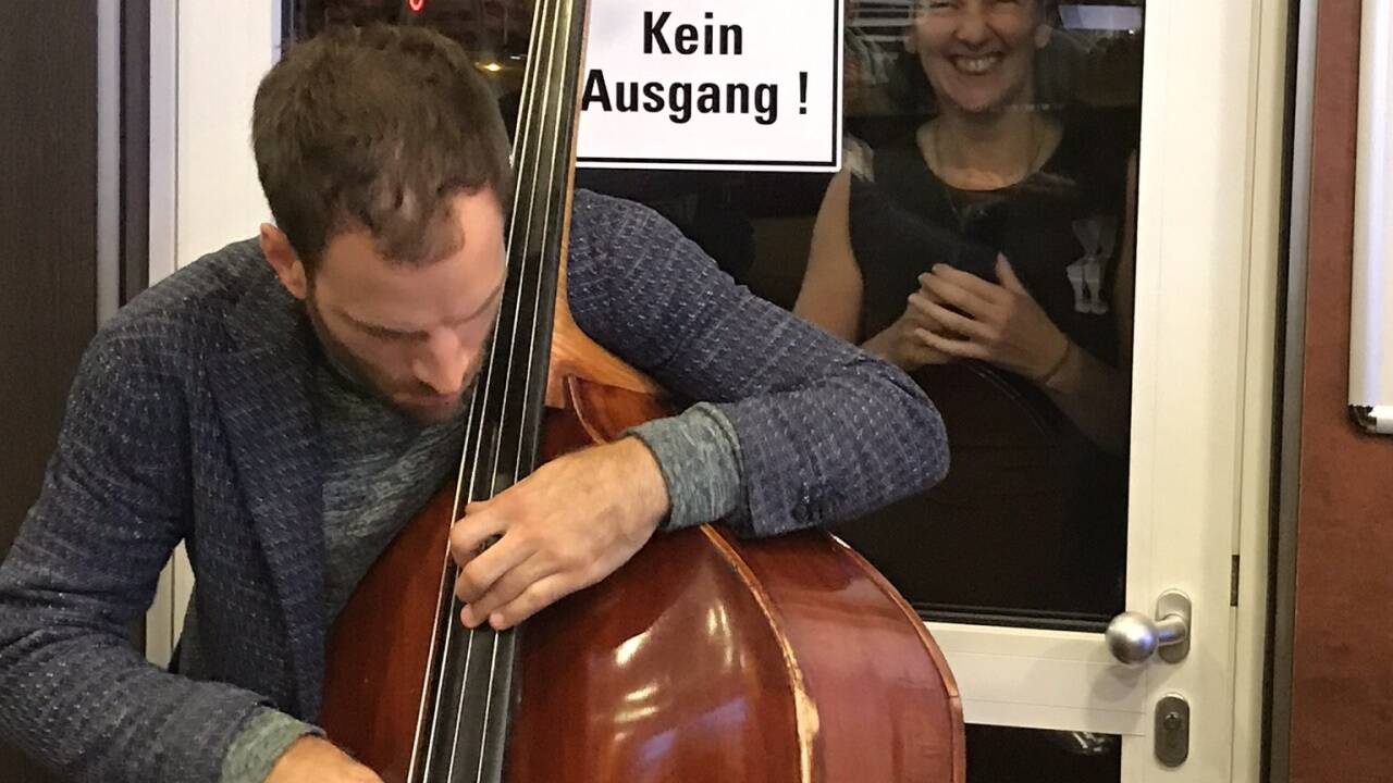 Bassist Lukas Kranzlbinder – Jazzfestival-Flashmob besucht McDonalds, im Hintergrund zu sehen Tina Heine, Intendantin von Jazz & The City Salzburg. 