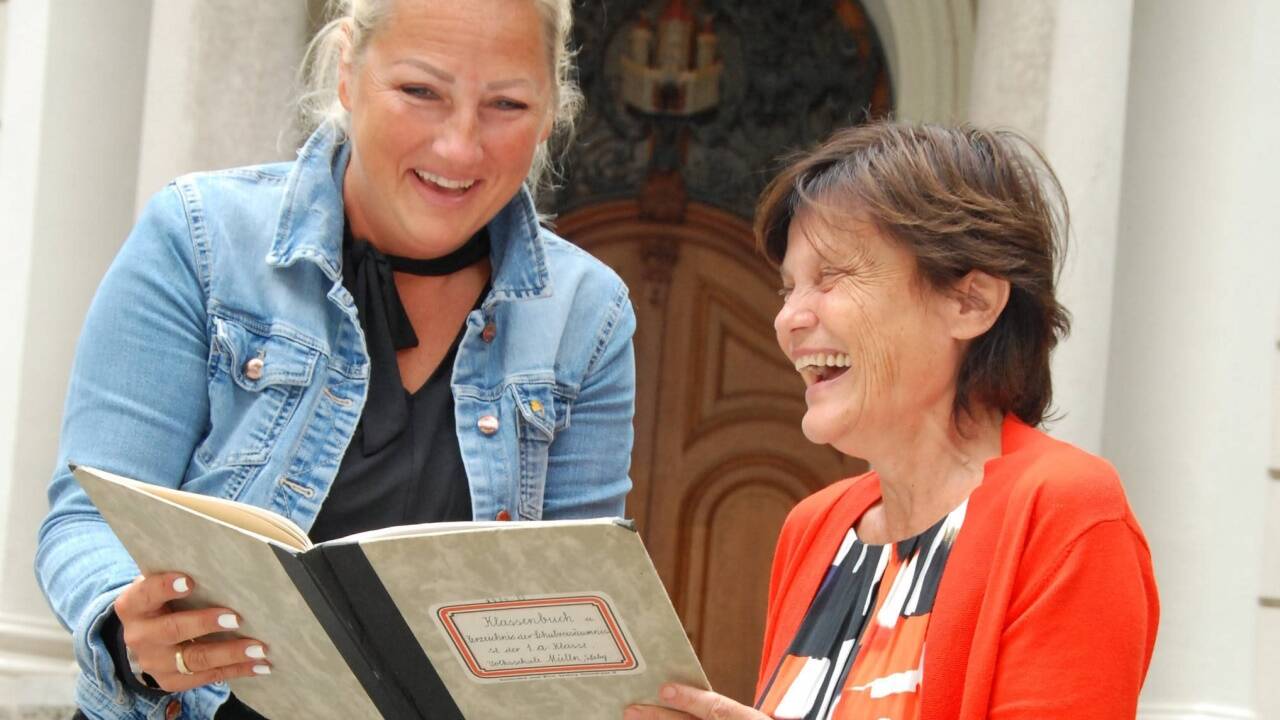 Schmökern im Klassenbuch aus 1951: Die scheidende Maria-Rose Gaßner (r.) und ihre Nachfolgerin Doris Unzeitig. Bild:  
