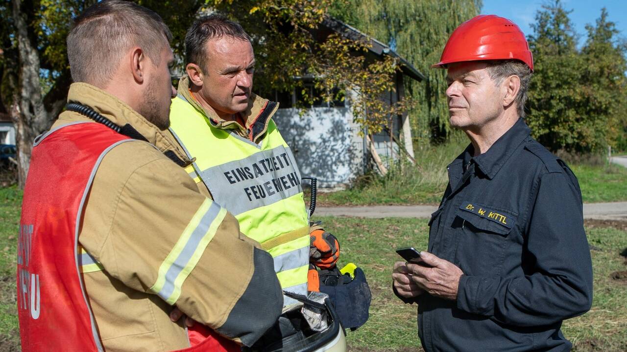 Brandsachverständige Walter Kittl mit Einsatzkräften der Feuerwehr am Brandort. 