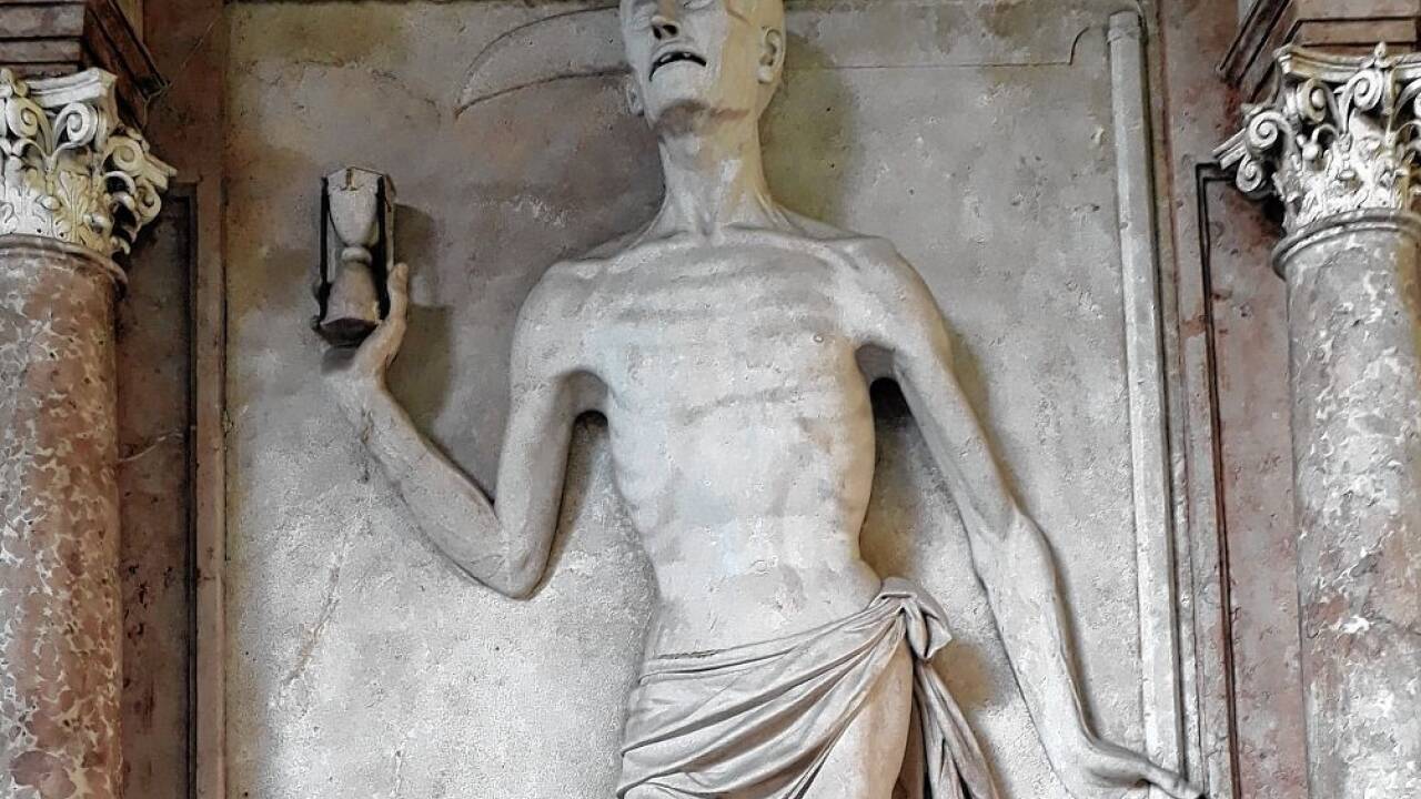 Symbole des Todes im Sebastiansfriedhof: der Sensenmann mit der Stundenuhr.  