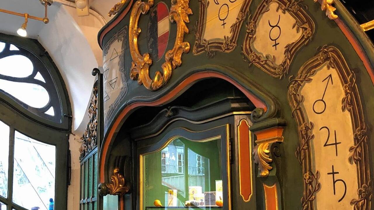 Blick in die „Alte fürsterzbischöfliche Hofapotheke“ am Alten Markt in Salzburg. Die „Geheimzeichen“ auf der ehemaligen Kassa aus 1912 erinnern an vielerorts vergessenes alchemistisches Wissen.  