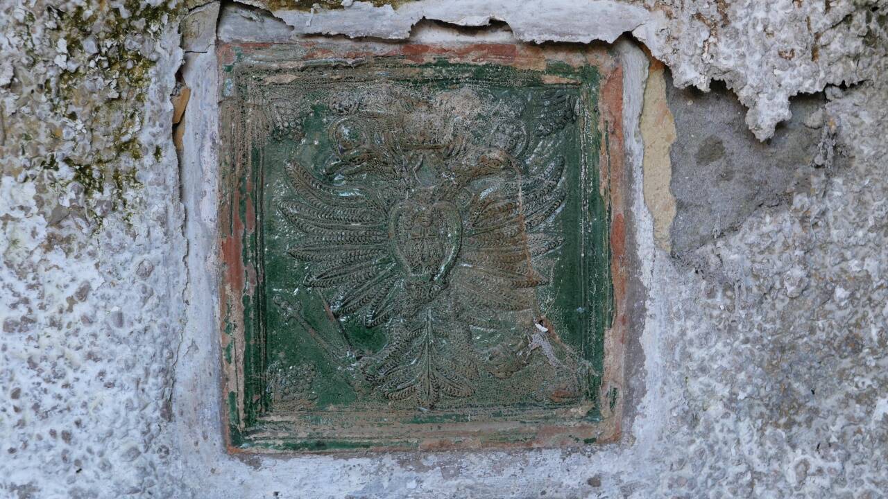 Eine kleine Kostbarkeit auf der Kellerfassade der Villa. Die Fliesen daneben wurden von Vandalen aus dem Mauerwerk geschlagen. Eine kleine Kostbarkeit auf der Kellerfassade der Villa. Die Fliesen daneben wurden von Vandalen aus dem Mauerwerk geschlagen.
