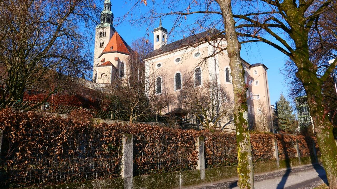 Blick von der Salzach auf das Gebäude, im Hintergrund die Müllner Kirche.  