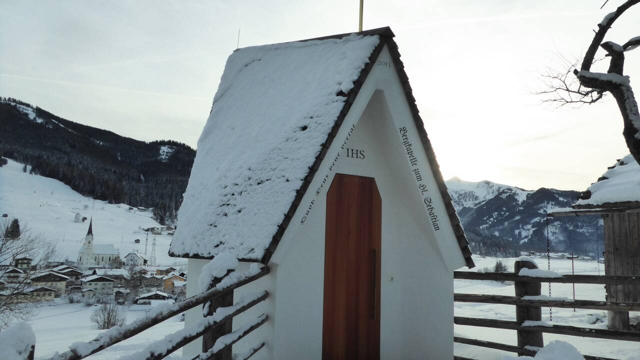 Die Sebastianskapelle mit Blick auf die Pfarrkirche von Embach.  