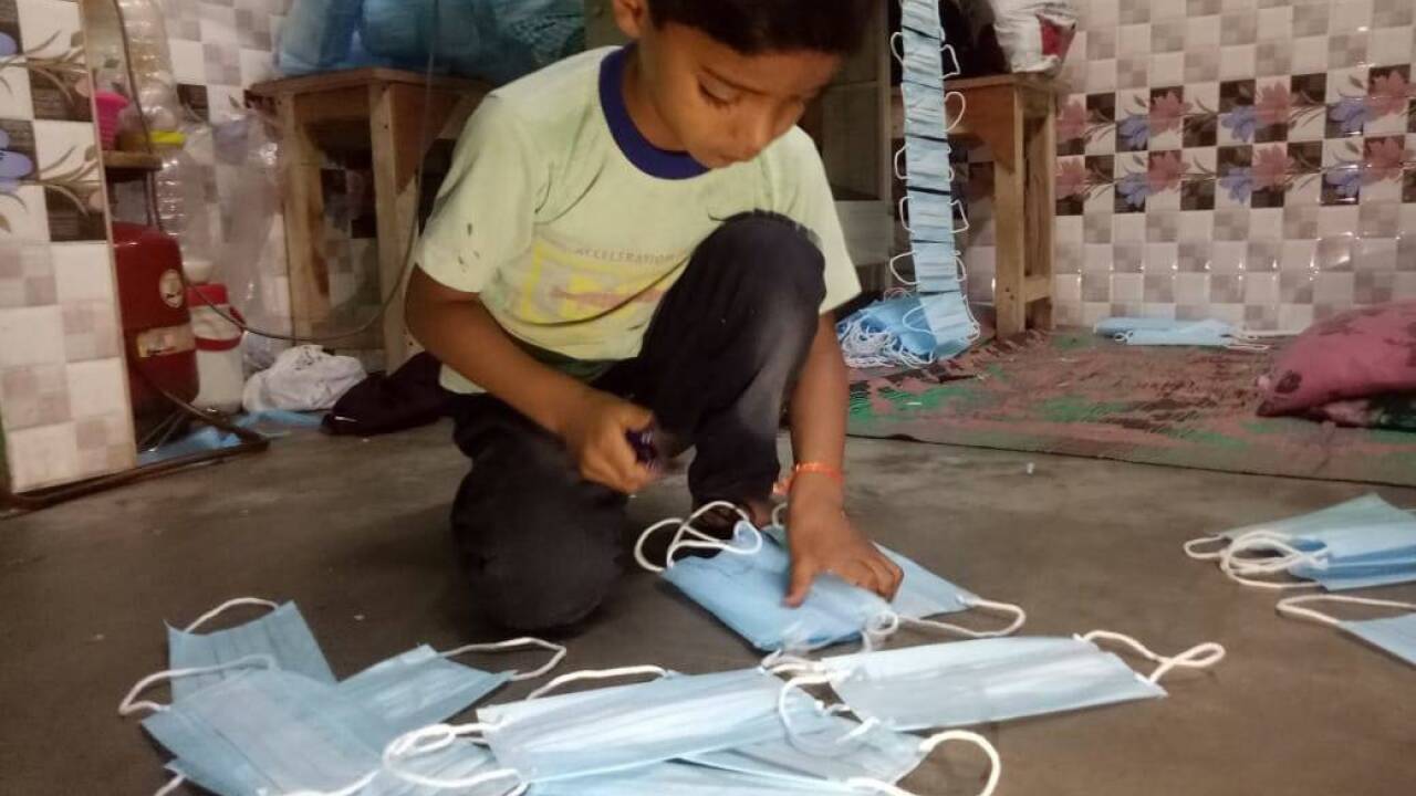 In der kleinen Wohnung der Familie Khan nähen auch die Kinder Masken, um den Lebensunterhalt der Familie verdienen zu können. In der kleinen Wohnung der Familie Khan nähen auch die Kinder Masken, um den Lebensunterhalt der Familie verdienen zu können.