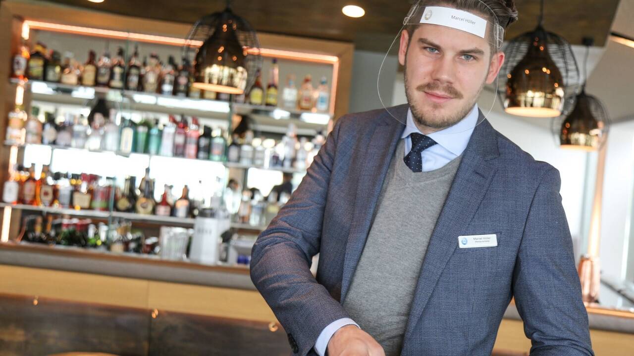 Servicepersonal muss Mundschutz oder Gesichtsschild tragen. Marcel Höllerin der Skybar des Hotels Imlauer in der Stadt Salzburg ist bestens gerüstet. 