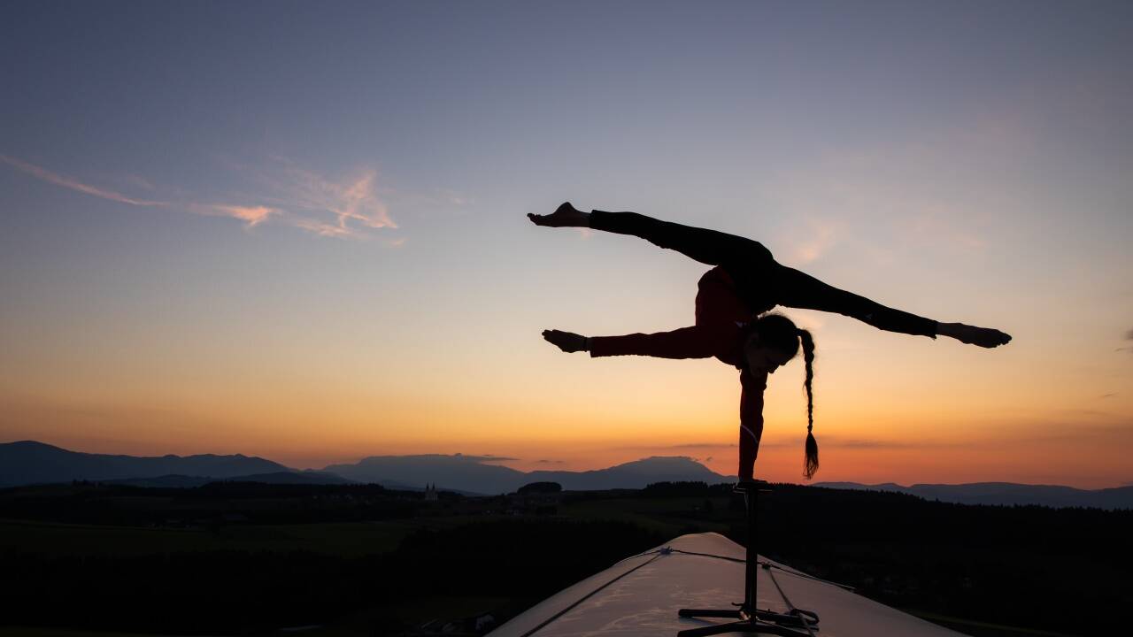 Die Salzburger Akrobatin Stefanie Millinger im Handstand auf dem Rotorblatt eines Windrades in 65 Meter Höhe. 