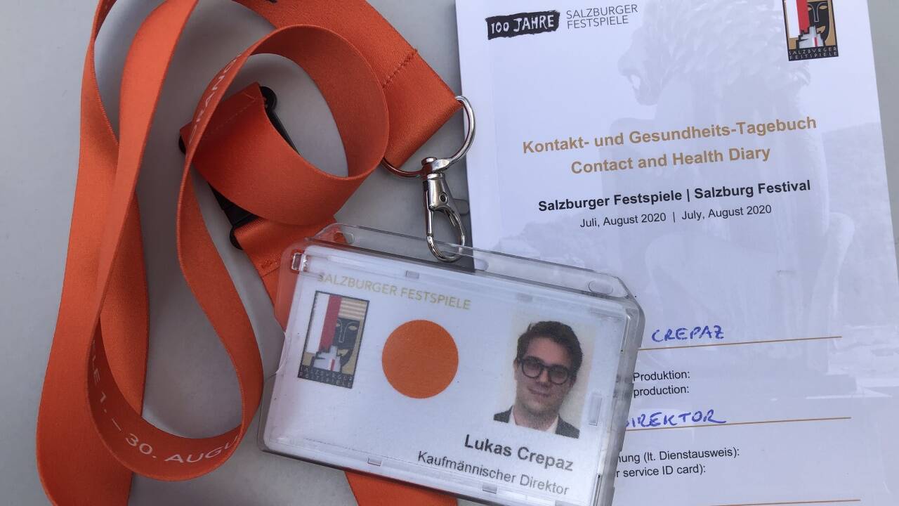 Utensilien des Kaufmännischen Direktors der Salzburger Festspiele bei Pandemiegefahr: Dienstausweis, oranges Band und Kontakttagebuch.  