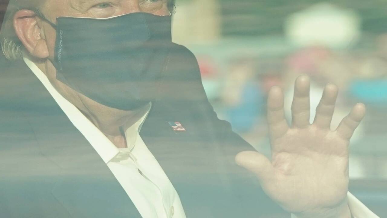 Hinter Panzerglas: Donald Trump trägt Maske und winkt seinen Fans zu. 