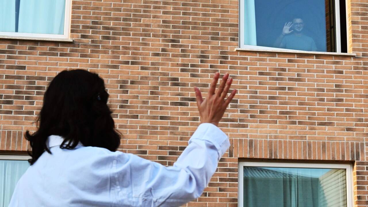  Christian Poretta, ein Krankenpfleger aus Rom, ist in Corona-Quarantäne. Er winkt seiner Arbeitskollegin zu.  