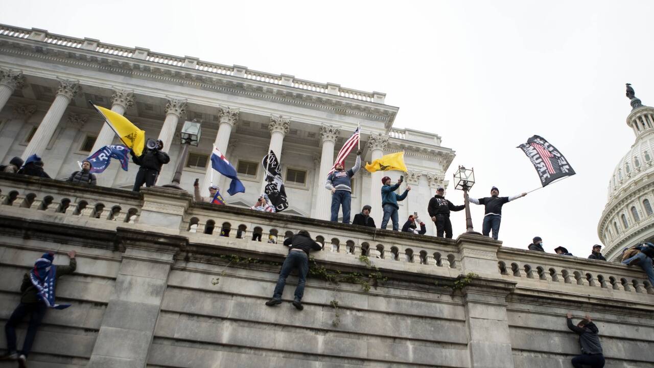 Triumphierend schwenken sie auf der Brüstung der Mauer ihre mitgebrachten Flaggen. 