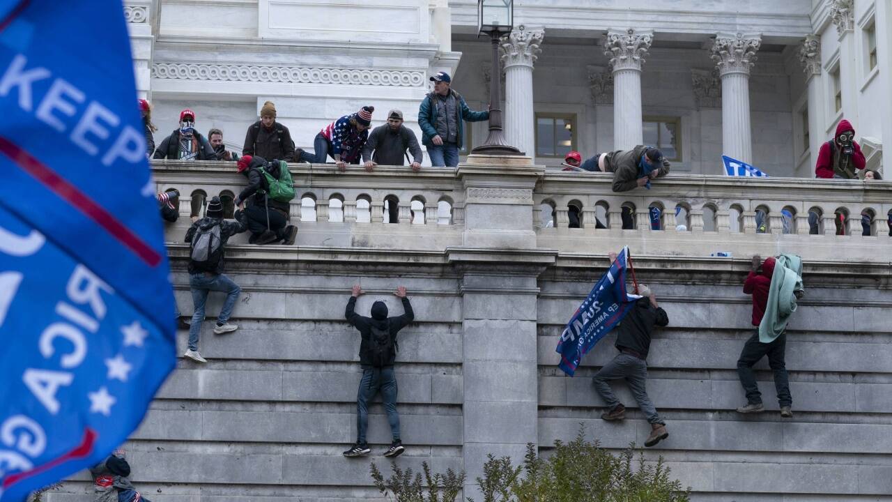 Trump-Anhänger klettern auf die Westwand des Kapitols. 