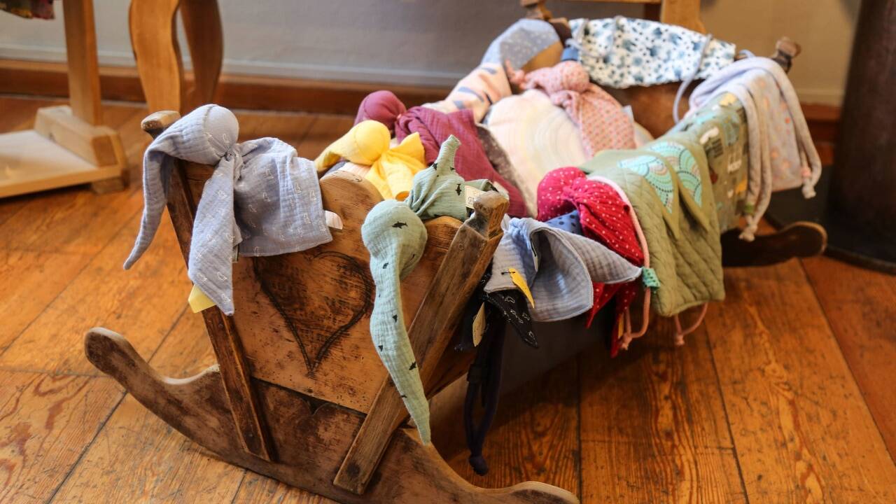 In einer alten Babywiege warten Soffwindelzwerge und Stoffsäcke auf Käuferinnen und Käufer. 