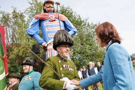 Landeshauptfrau Edtstadler gratuliert Schützenhauptmann Herbert Wallmann (im Hintergrund der Samson).  