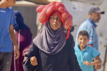 Eine Palästinenserin trägt in Rafah eine Lebensmittelration. 