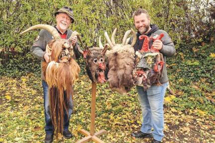 Hans und Sohn Hannes Brugger zeigen heuer im Zuge des 50. Gnigler Krampuslaufs alte Krampus-Masken in der Auslage von Tapezierer Brugger. Die im Bild stammen von 2000, 1972, 1966 und 1989.  