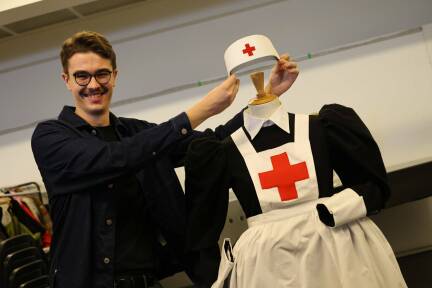 Tobias Schneider-Lenz mit dem Kostüm einer Krankenschwester aus der Oper „Die Zauberflöte“. 