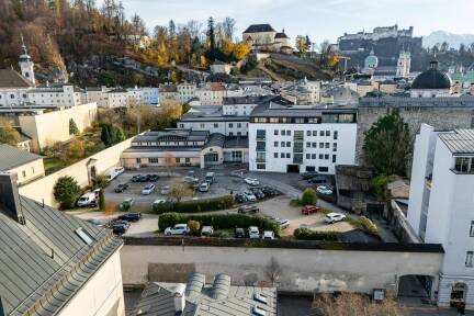 Blick auf den Priesterhausgarten, der als Parkplatz dient. 