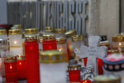 Ein Kreuz mit der Aufschrift „Wir vermissen dich“ und Kerzen vor dem BORG in Graz nach dem Amoklauf am 10. Juni 2025. 