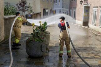 Wasser marsch – die Feuerwehr säubert die schlammbedeckten Straßen und Gassen der Halleiner Innenstadt. 